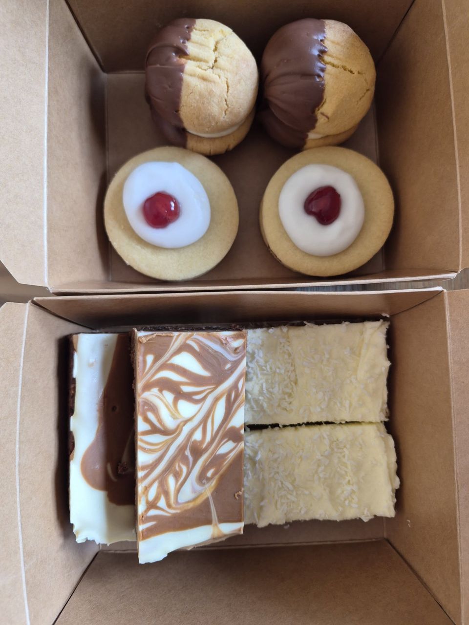 Box of cherry topped biscuits, dipped biscuits and tray bakes