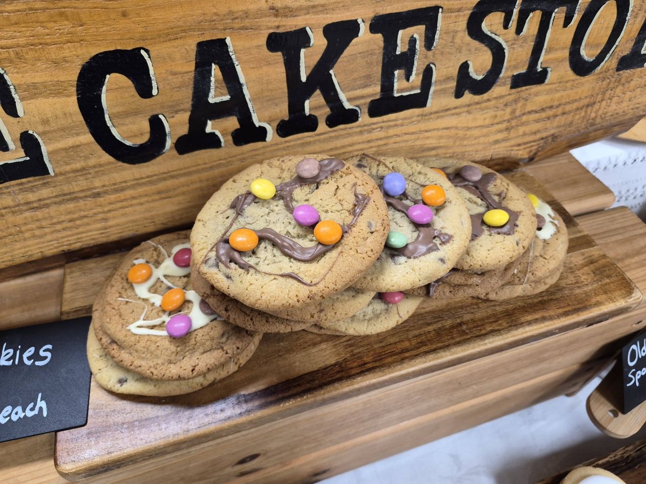 Cookies in front of The Wee Cake Stop wooden sign